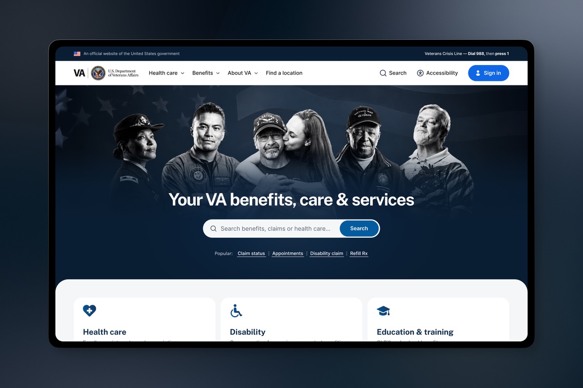Direction two: the same entry screen with a photographic hero. A black-and-white montage of five Veterans and a family member over a flag fills the space behind the headline, search field, and popular task links, pushing the benefit cards out of the visible area.
